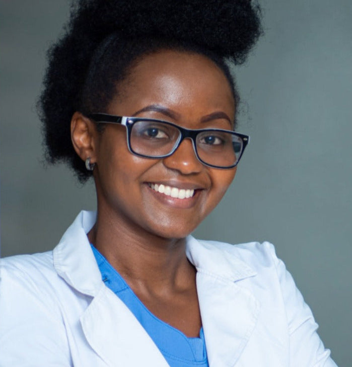 Woman wearing a white coat and glasses with a gray background